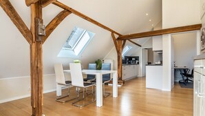 Een moderne loftkamer met een eethoek, keuken en dakramen.