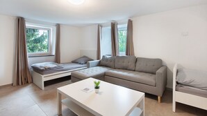 Ein modernes Wohnzimmer mit Sofa, Couchtisch und Bett.