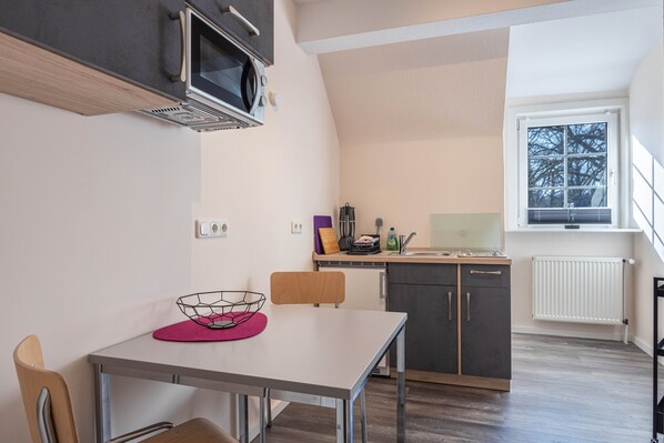 A compact kitchen with a microwave, sink, and window. - Apartment 'Haus Wacholder 2' with Balcony and Wi-Fi (Undeloh)