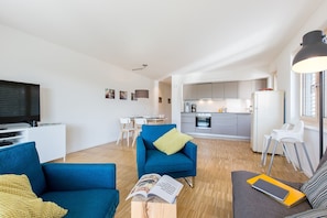 A modern apartment with a living room, dining area, and kitchen.