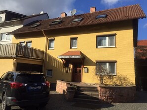 A yellow building with a sign reading 'Gastehaus - Quelle'. - Apartment 'Spessart' with Shared Terrace, Shared Garden and Wi-Fi (Wächtersbach)