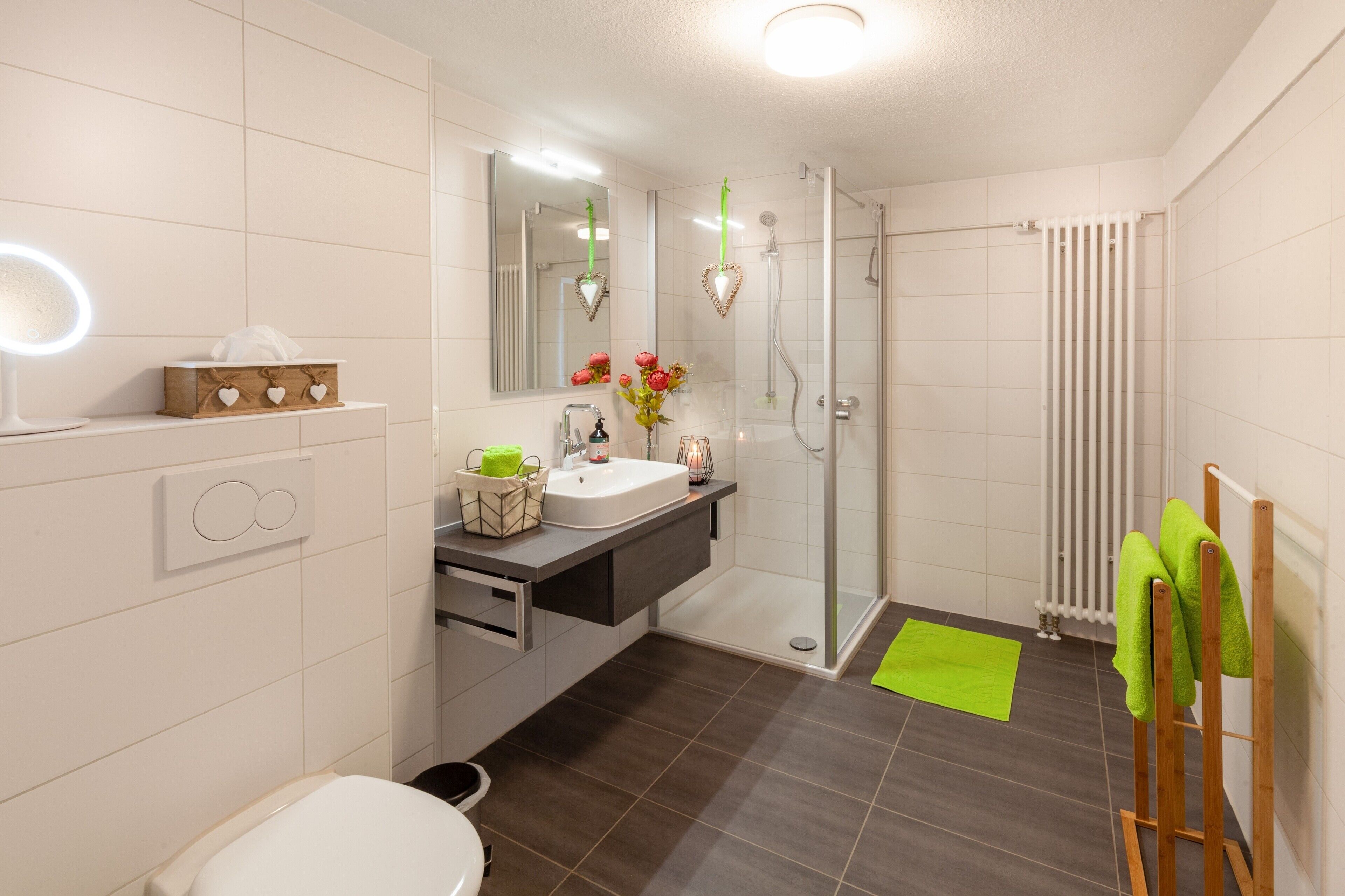 A modern bathroom with a shower, toilet, and sink.