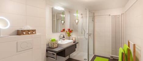 A modern bathroom with a shower, toilet, and sink.