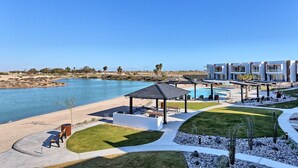 Un resort con piscina, asientos al aire libre y vista al agua.