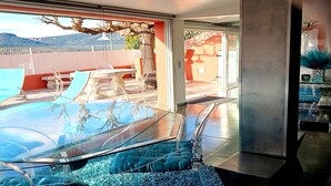 A modern interior with a glass table, clear chairs, and a view of the outdoors. - Village House in France with Private Pool (Bagnols-en-Forêt)