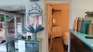 A hotel lobby with a modern design, including a reception desk, a decorative mirror, and a small seating area. - Village House in France with Private Pool (Bagnols-en-Forêt)