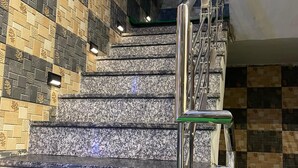 A staircase with a metal handrail and a patterned wall. - Hotel Paradise - Chandigarh (Chandigarh)