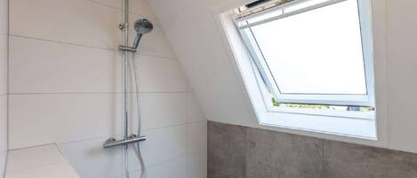 A skylight window in a bathroom with a showerhead.