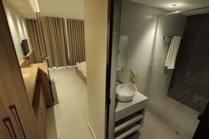 A modern bathroom with a large mirror, a sink, and a shower area. - The Brook Serene – A Nature Themed Boutique Resort, Kollam (Kollam)