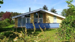 A single-story house with a gabled roof, large windows, and a blue front porch. - Ferienhaus mit Sauna im Ferienpark Mirow (Granzow)