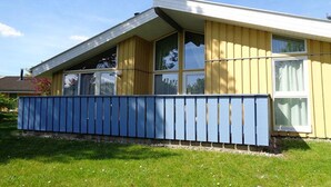 A yellow building with large windows and a blue fence. - Ferienhaus mit Sauna im Ferienpark Mirow (Granzow)