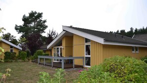 Un bâtiment jaune doté d’un porche abrité et d’une petite terrasse.