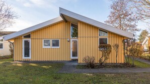 Yhden kerroksen korkuinen keltainen rakennus, jossa on harjakatto, pääovi ja pieni ikkuna.