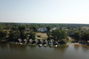 Un village au bord d’un lac, avec des maisons qui bordent la rive et un grand bâtiment situé au centre.