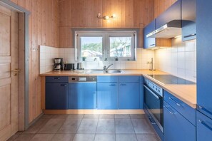 Une cuisine moderne avec des murs en bois, une fenêtre et un lave-vaisselle.