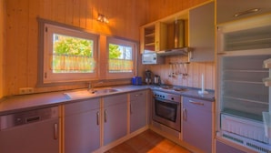 Una cocina compacta con armarios de madera, estufa y refrigerador.