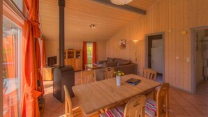 Un interior de madera con una mesa de comedor, sillas, un sofá y una chimenea.