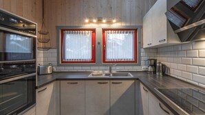 Una cocina moderna con electrodomésticos de acero inoxidable, un lavamanos doble y armarios de madera.