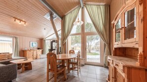 Un intérieur en bois comprenant un coin repas, un canapé et une cuisine.