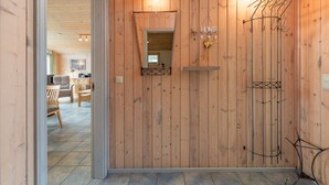 Un intérieur en bois agrémenté d’un miroir, d’une enseigne portant le mot « HOME » et d’un porte-manteau.