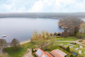 A lakeside property with multiple cabins, a dock, and solar panels. - Ferienhaus mit Sauna im Ferienpark Mirow (Granzow)