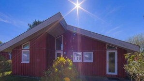 A red building with a sloped roof and multiple windows. - Ferienhaus mit Sauna im Ferienpark Mirow (Granzow)