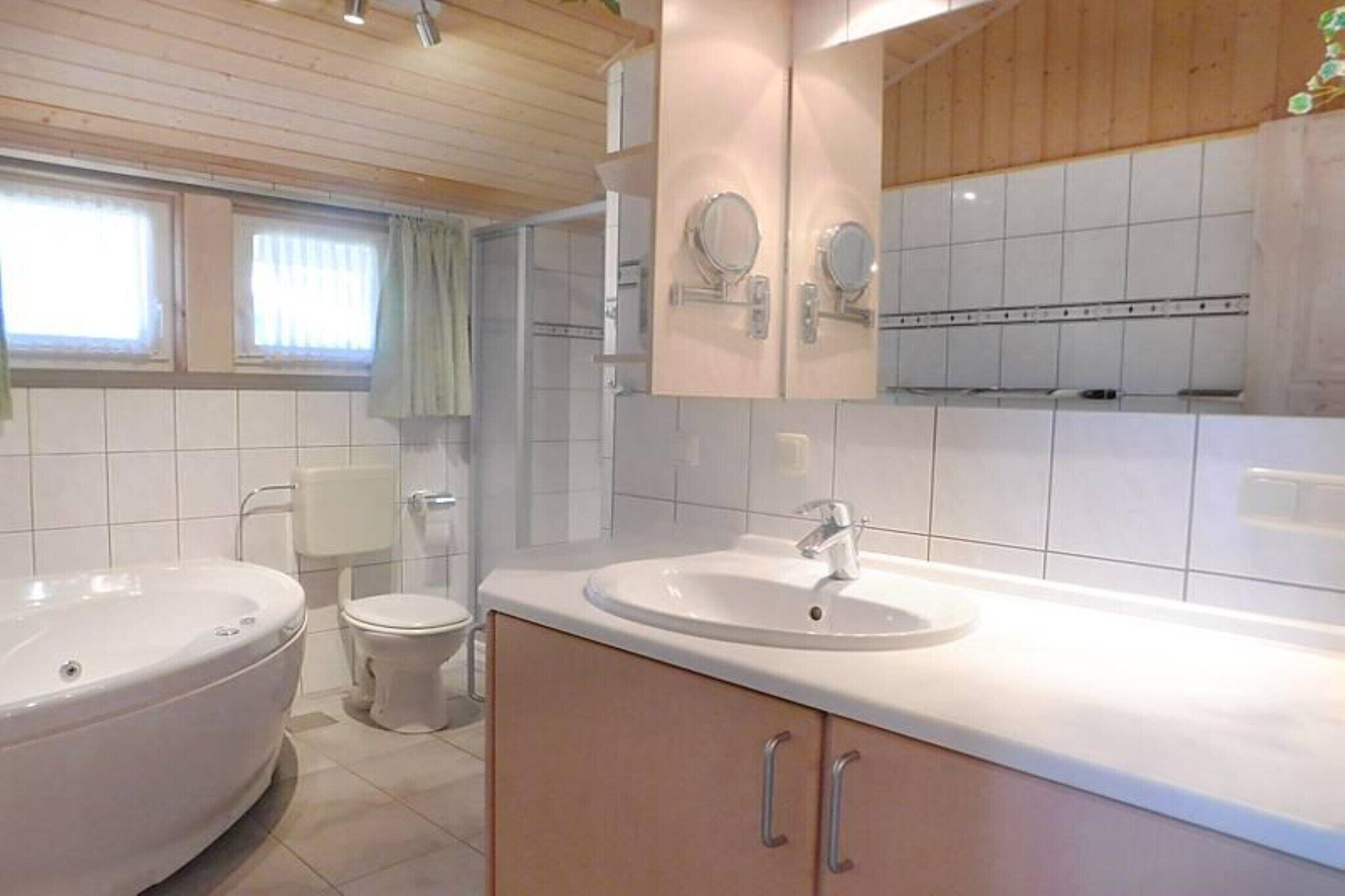 Ett modernt badrum med badkar, toalett och handfat.