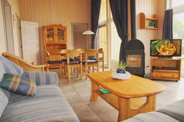 A cozy living room with a sofa, wooden coffee table, and a television.