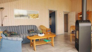 Una sala de estar acogedora con un sofá, una mesa de madera y una chimenea negra.