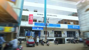 A multi-story building with signage for M.R. Complex and Mr. Dwell Hotel. - MR DWELL HOTEL AIRPORTZONE (Hyderabad)