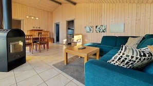 Een modern interieur met een houten wand, een bank, een tafel en een open haard.