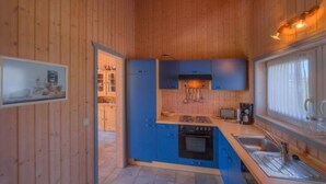 Une cuisine de taille réduite avec des meubles bleus, une cuisinière et un évier.
