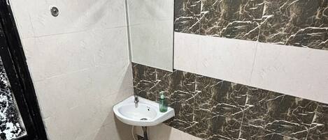 A bathroom with a toilet, sink, and mirror.