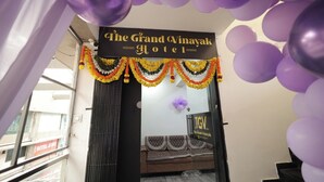 The entrance of The Grand Vinayak Hotel with a sign above the door and a view of the interior including a sofa and a patterned rug. - The Grand Vinayak Hotel (Surat)