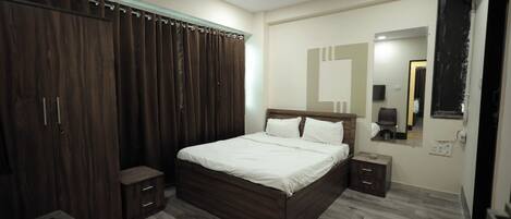 A bedroom with a wooden bed, a wardrobe, a nightstand, a mirror, and a ceiling fan.