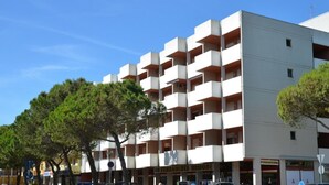 Un immeuble à plusieurs étages, doté d’une façade blanche et de balcons rouges.
