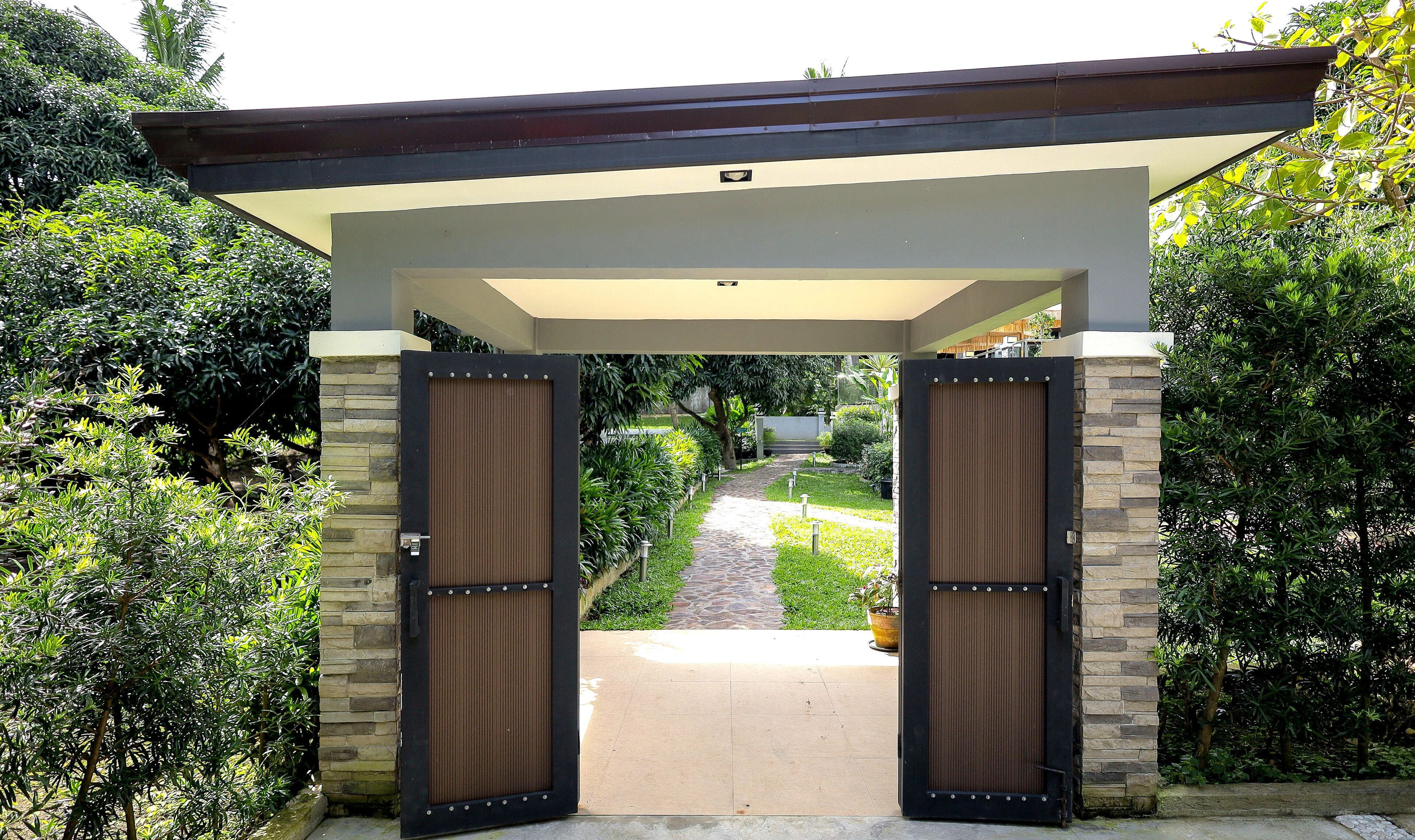 A gated entrance with a pathway leading through a landscaped garden.