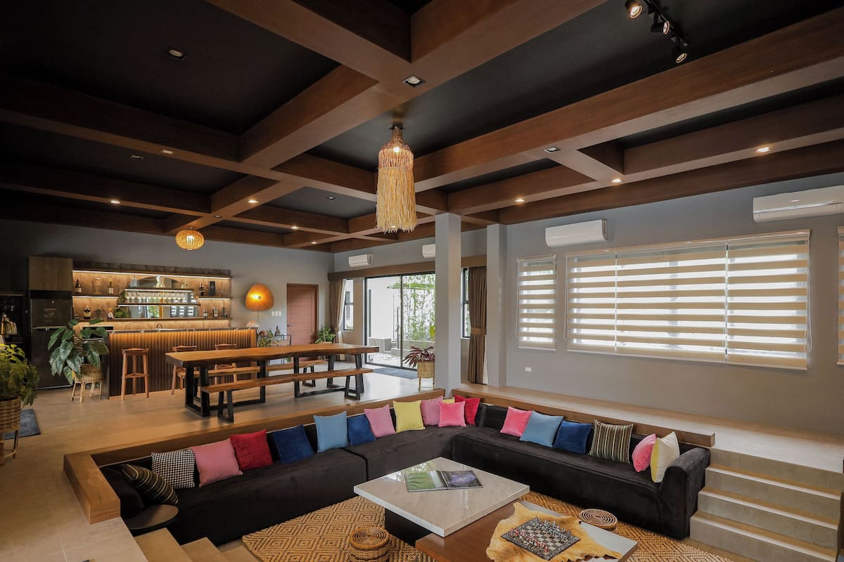 A modern living room with a sectional sofa, a coffee table, and a bar area with a counter and stools.