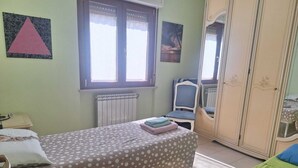 A room with a bed, a chair, a wardrobe, and a window. - Large and bright apartment in residential area, 6 bus stops from metro A (Roma)