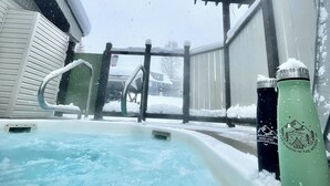 A hot tub with a metal frame and railings, surrounded by snow-covered walls and a roof. - Small Cabin, Big Comfort. Ski-in/Ski-Out, Hike, Bike & Chill. Hot Tub & Sauna. (Kimberley)