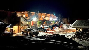 A nighttime view of a residential street with houses and parked cars. - Small Cabin, Big Comfort. Ski-in/Ski-Out, Hike, Bike & Chill. Hot Tub & Sauna. (Kimberley)