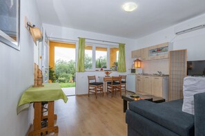 Un espacio habitable compacto con comedor, kitchenette y sofá.