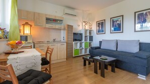 A modern living room with a sofa, coffee table, and dining area with chairs and a table.