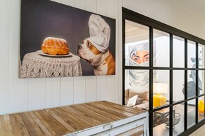 Artwork and a table adorn the wall in this stylish room.