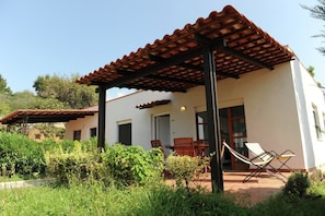 A house with a patio, a covered outdoor seating area, and a door leading to the interior.