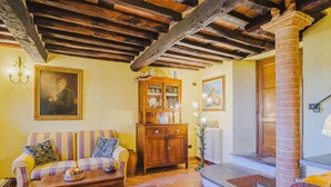 Un salon chaleureux avec un canapé en bois, un meuble et un escalier menant à l’étage supérieur.