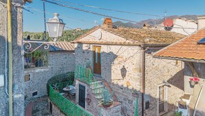 Un bâtiment en pierre doté d’un petit balcon, d’une porte et d’une fenêtre.