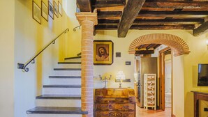 Un escalier avec des marches en marbre, une colonne en bois et un plafond rustique.