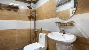 Baño con ducha, inodoro y lavamanos.
