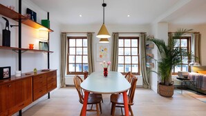 A dining area with a table, chairs, a hanging light, and a potted plant. - The Lancaster Gate Mews House, by Veeve (London)